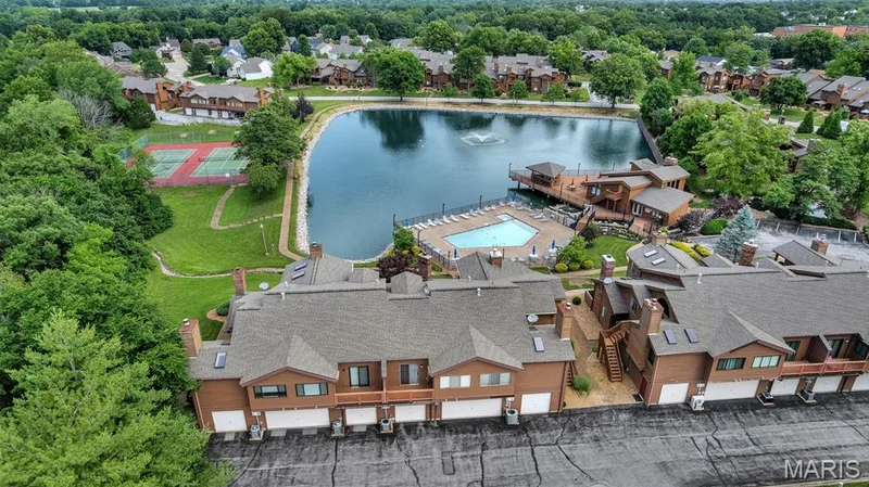 Step from recreational tennis court, a community swimming pool, a private lake with a central fountain, and a waterside deck — 309 Hemingway Lane, Weldon Spring, MO 63304