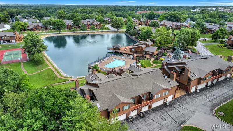 Community featuring a central pond with a fountain, a tennis court, and an outdoor swimming pool with surrounding lounge areas — 309 Hemingway Lane, Weldon Spring, MO 63304