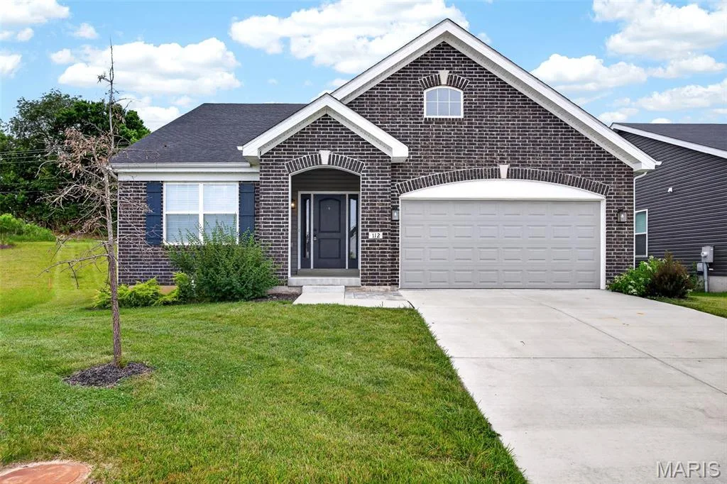 Brick exterior with arched entryways and a two-car garage — 112 Creek Haven Court, Lake St. Louis, MO 63367