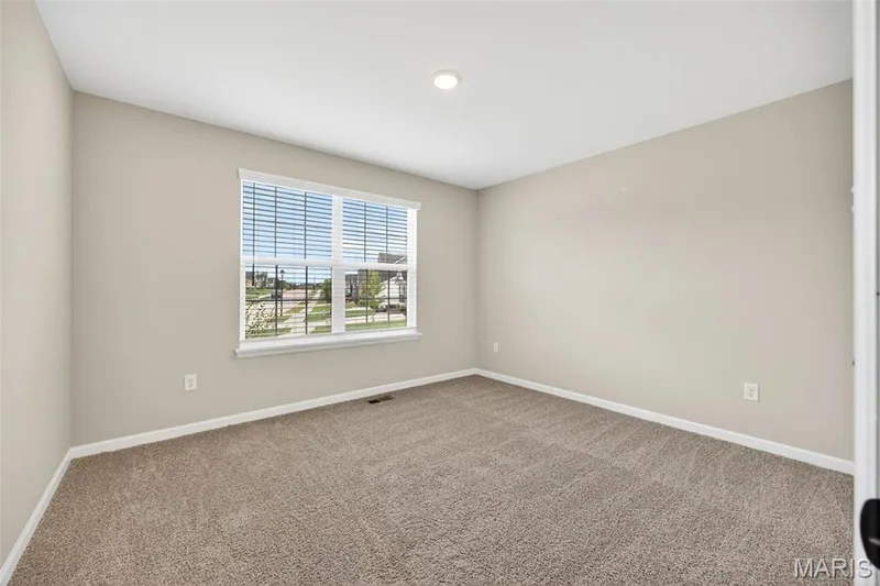 Spacious room featuring neutral carpeting and light neutral wall paint — 112 Creek Haven Court, Lake St. Louis, MO 63367