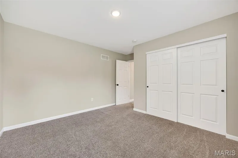 Spacious room featuring neutral paint, gray carpet, white baseboards, and a recessed ceiling light — 112 Creek Haven Court, Lake St. Louis, MO 63367
