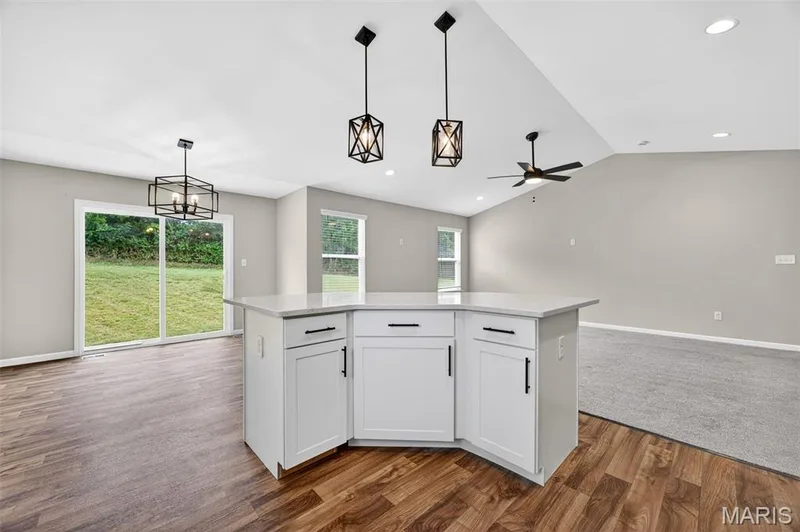 Central kitchen island with white cabinetry and a light-toned countertop — 112 Creek Haven Court, Lake St. Louis, MO 63367
