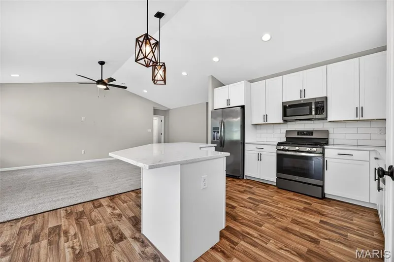 Modern kitchen featuring white shaker cabinetry, stainless steel appliances, and a subway tile backsplash — 112 Creek Haven Court, Lake St. Louis, MO 63367