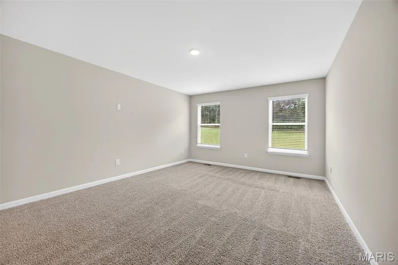Spacious room featuring neutral carpeting and light gray wall tones — 112 Creek Haven Court, Lake St. Louis, MO 63367