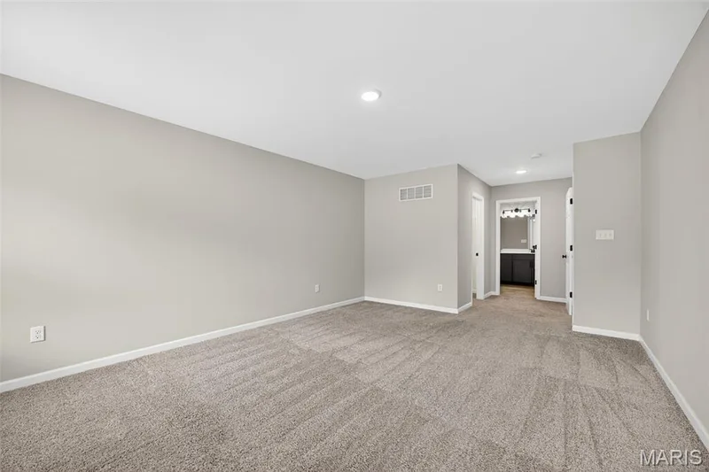 Spacious room featuring neutral carpeting and light gray wall paint — 112 Creek Haven Court, Lake St. Louis, MO 63367