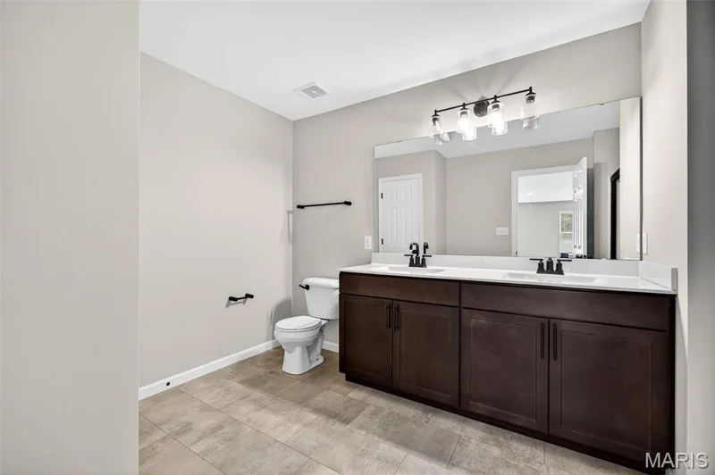 Dual vanity with white countertops, undermount sinks, and matte black fixtures — 112 Creek Haven Court, Lake St. Louis, MO 63367