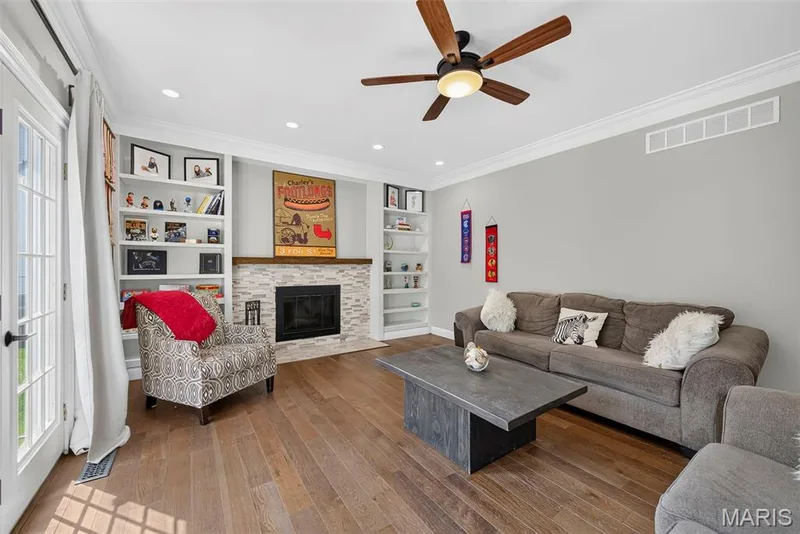 The family room ha great built-ins, the rich wood floors that run throughout most of the main, and lighted ceiling fan. — 2024 Meadowbrook Way Drive, Chesterfield, MO 63017