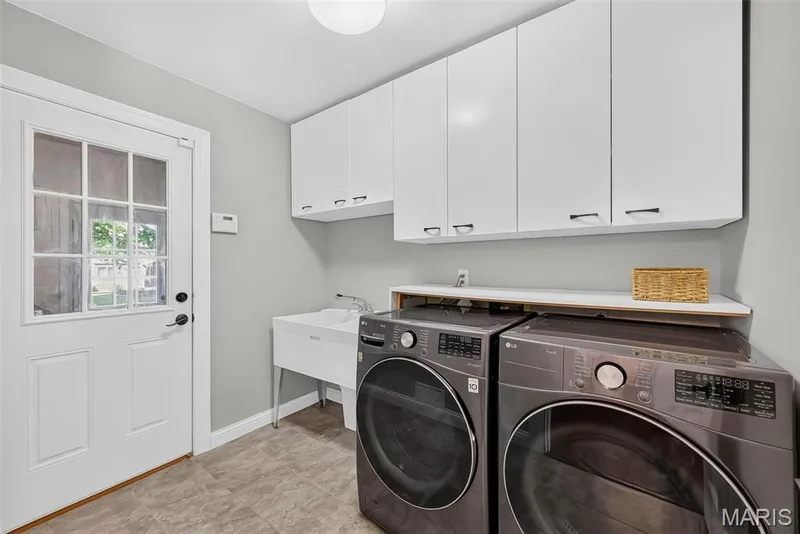 Laundry room with utility sink, and door out to an additional "drop zone" and then the garage. — 2024 Meadowbrook Way Drive, Chesterfield, MO 63017