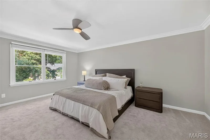 Primary bedroom with new carpet, crown molding, neutral paint, and lighted ceiling fan. — 2024 Meadowbrook Way Drive, Chesterfield, MO 63017