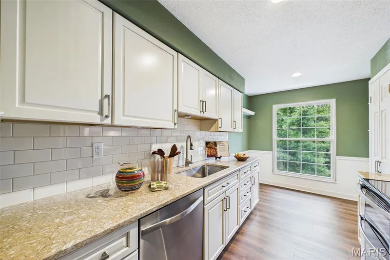 Updated kitchen boast newer cabinets, hard surface and place for table enjoying view of mature landscaping. — 1525 Hampton Hall Drive #22, Chesterfield, MO 63017