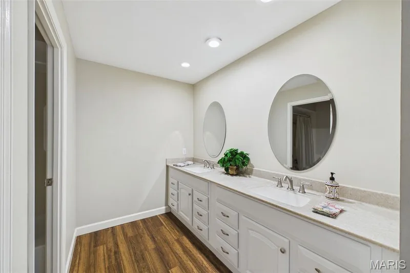Updated second bathroom with white cabinets and hard surface counters, wood-like flooring — 1525 Hampton Hall Drive #22, Chesterfield, MO 63017
