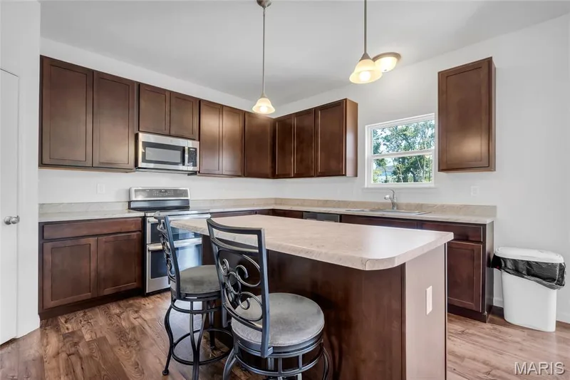 Kitchen area with stainless appliances, breakfast bar and plenty of countertop space. — 425 Dusty Brook Drive, O'Fallon, MO 63366