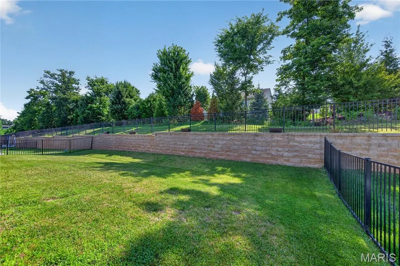 Mostly Level Backyard featuring Landscape Wall & TREES offering LOTS of SHADE! — 156 Hidden Bluffs Drive, Lake St. Louis, MO 63367