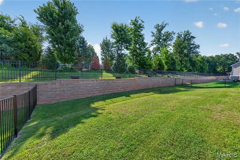 Mostly Level Backyard featuring Landscape Wall & TREES offering LOTS of SHADE! — 156 Hidden Bluffs Drive, Lake St. Louis, MO 63367
