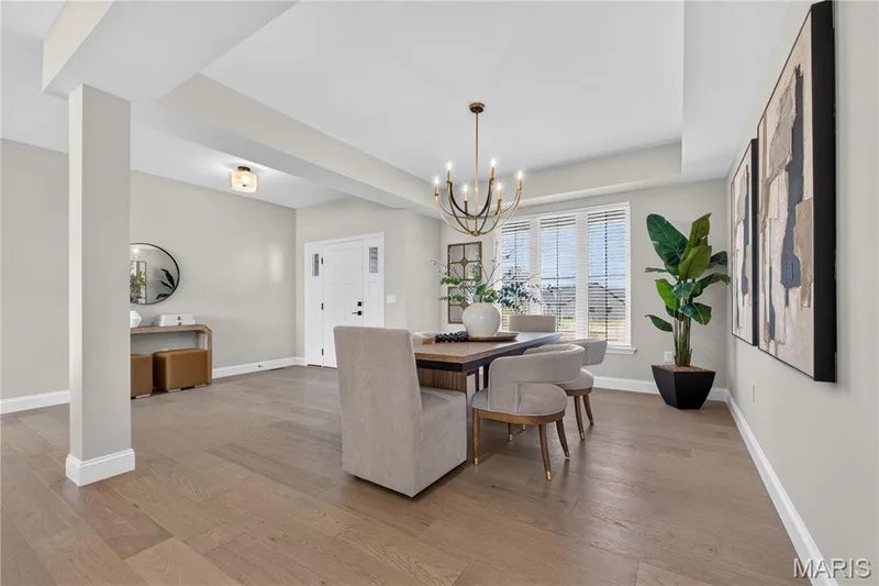 Wood-finish flooring, recessed ceiling beams, and a brass chandelier illuminate the space — 26 Valor Way, O'Fallon, MO 63385
