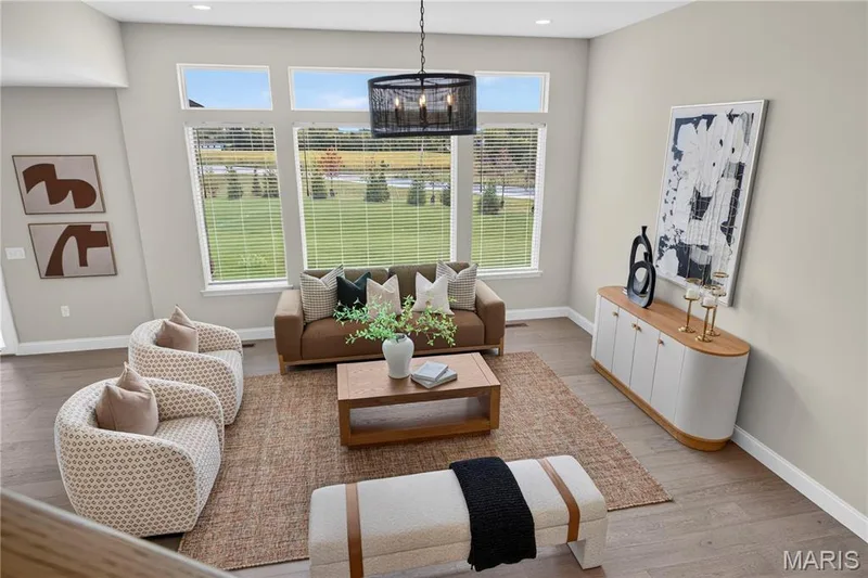 11' ceilings, wood-finish flooring, and large windows with blinds create an inviting living space — 26 Valor Way, O'Fallon, MO 63385