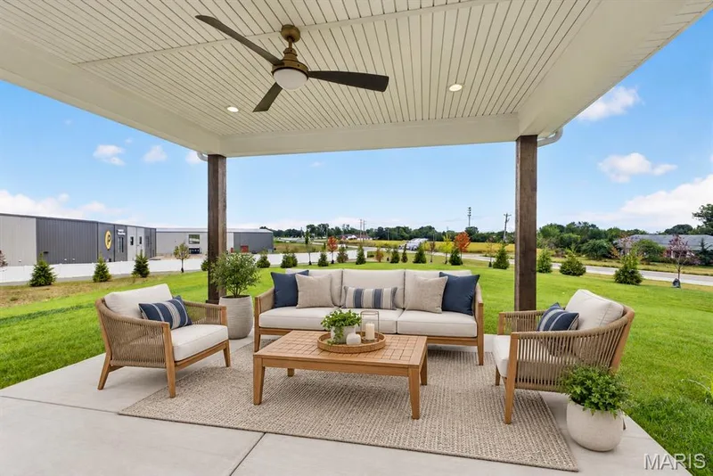 Covered patio featuring a ceiling fan, recessed lighting, and structural wood-look columns — 26 Valor Way, O'Fallon, MO 63385
