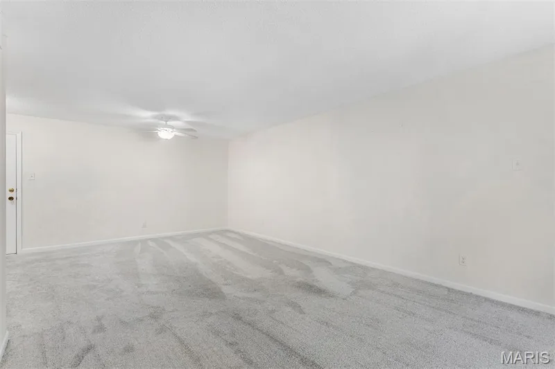 Ceiling fan, wall-to-wall carpeting, and a white interior door with brass hardware — 1511 Hampton Hall Drive #10, Chesterfield, MO 63017