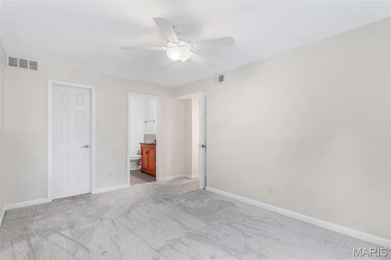 Gray carpeted flooring with light-toned wall finishes and a ceiling fan with integrated lighting — 1511 Hampton Hall Drive #10, Chesterfield, MO 63017