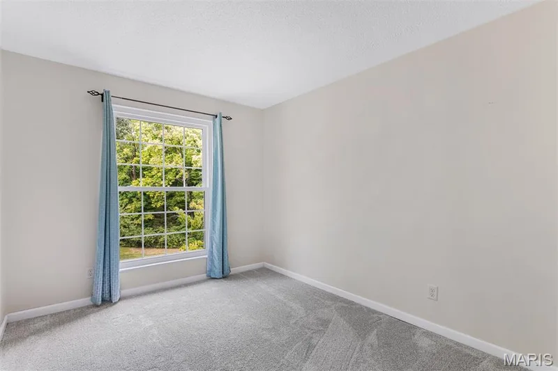 Window with grilles and exterior greenery, light-colored walls, and textured carpeting — 1511 Hampton Hall Drive #10, Chesterfield, MO 63017
