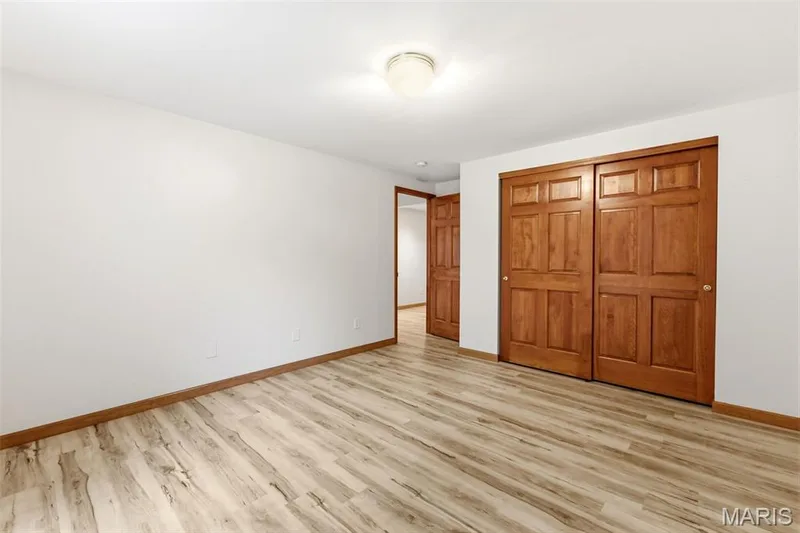 Spacious room with wood-finish flooring and white walls — 3515 Truman Terrace Drive #65, St Charles, MO 63301