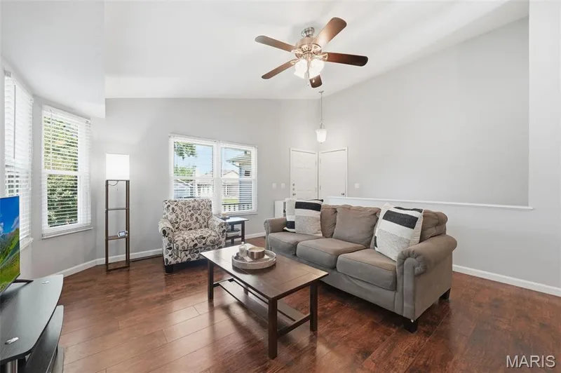 Living area featuring wood-finish flooring, vaulted ceilings, and a ceiling fan with integrated lighting — 2510 Balaji Court, Wildwood, MO 63011