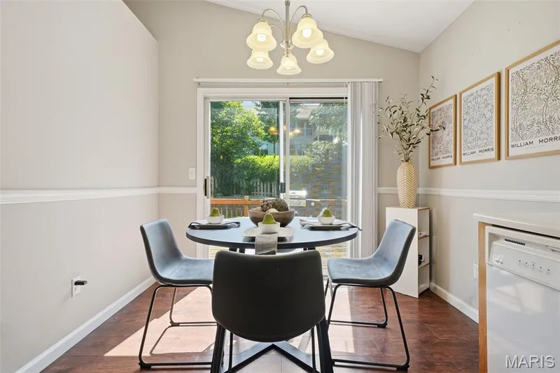 Dining area featuring a vaulted ceiling, wood-finish flooring, and a sliding glass door providing access to the exterior — 2510 Balaji Court, Wildwood, MO 63011