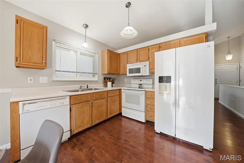 Kitchen featuring a double basin stainless steel sink, wood-finish flooring, and light wood cabinetry — 2510 Balaji Court, Wildwood, MO 63011