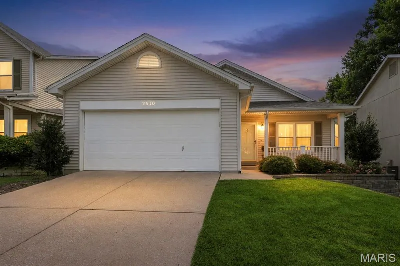 Single-story residence featuring light-colored siding, an attached two-car garage, and a covered front porch — 2510 Balaji Court, Wildwood, MO 63011