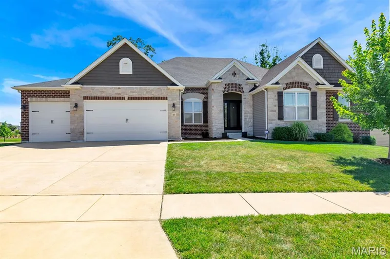 Contemporary single-story residence showcasing a brick and stone facade with shake accent gables — 401 Hamlet Court, O'Fallon, MO 63367
