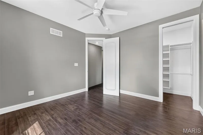 Wood-finish flooring, white trim, ceiling fan, and a built-in closet organization system — 401 Hamlet Court, O'Fallon, MO 63367