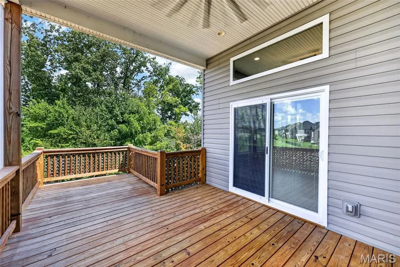 Expansive wood-finish deck with decorative wood railing — 401 Hamlet Court, O'Fallon, MO 63367