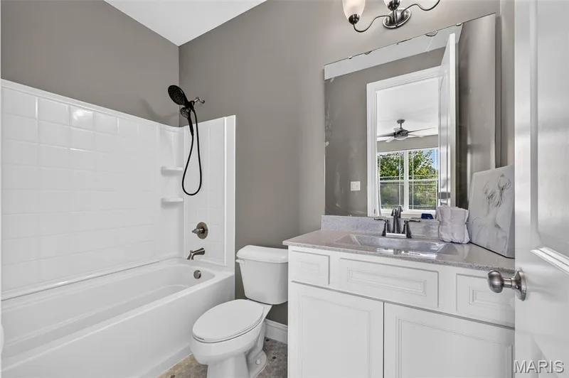 White vanity with a neutral-toned countertop and an undermount sink — 401 Hamlet Court, O'Fallon, MO 63367