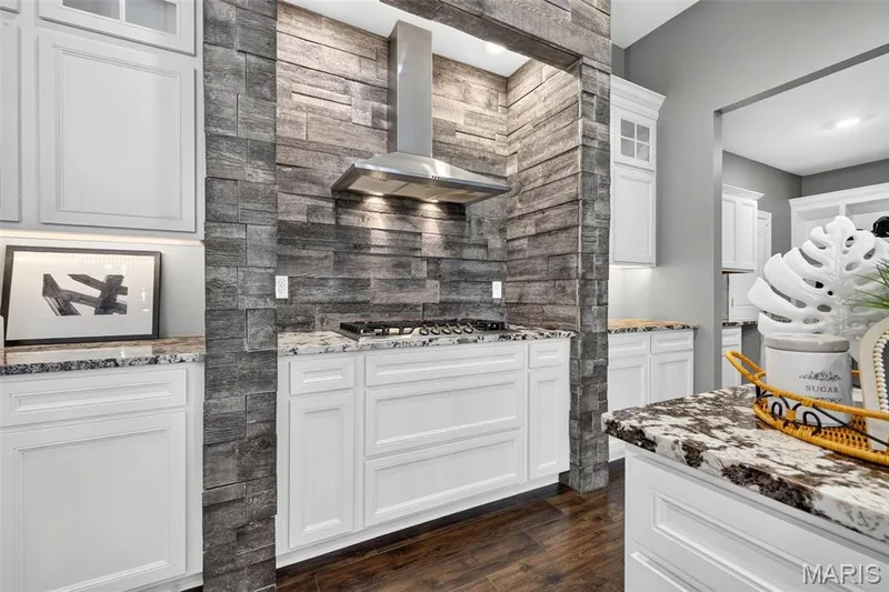 White cabinetry with under-cabinet lighting, wood-finish flooring, and granite countertops — 401 Hamlet Court, O'Fallon, MO 63367