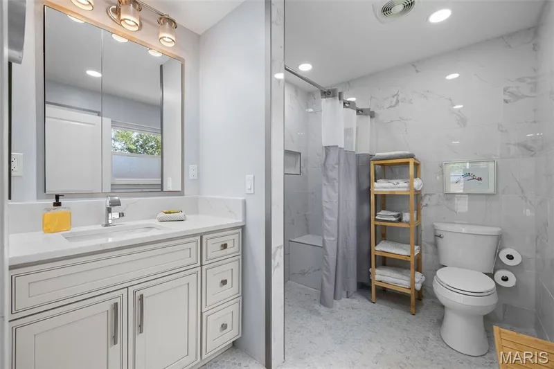 Primary bath has been completely remodeled with floor-to-ceiling marble, ADA "easy clean" toilet, non-slip ceramic tile and a zero entry shower — 312 Diplomat Lane, Chesterfield, MO 63017