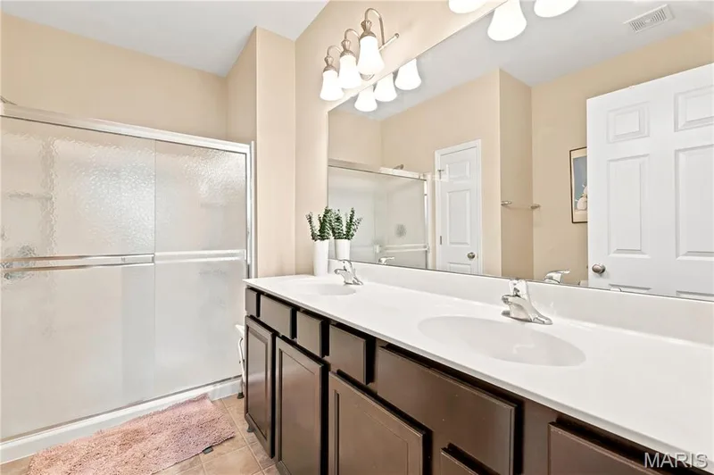 Bathroom featuring a dual vanity, walk-in shower and linen closet. — 226 City Gate Lane, St Charles, MO 63303