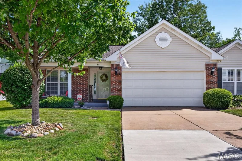 Brick and siding exterior featuring a two-car garage — 30 Hunting Manor Drive, St Charles, MO 63303
