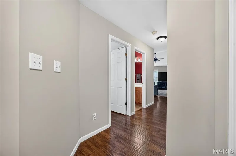 Hallway featuring wood-finish flooring, light-toned wall paint, and white trim — 30 Hunting Manor Drive, St Charles, MO 63303