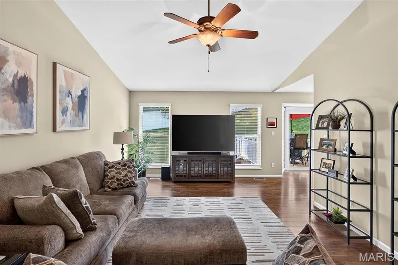 Spacious living area featuring a vaulted ceiling and wood-finish flooring — 30 Hunting Manor Drive, St Charles, MO 63303