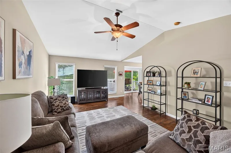 Spacious living area featuring vaulted ceilings with a ceiling fan, wood-finish flooring, and light-toned walls — 30 Hunting Manor Drive, St Charles, MO 63303