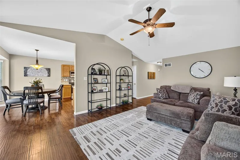 Living area featuring vaulted ceilings, wood-finish flooring, and a ceiling fan — 30 Hunting Manor Drive, St Charles, MO 63303