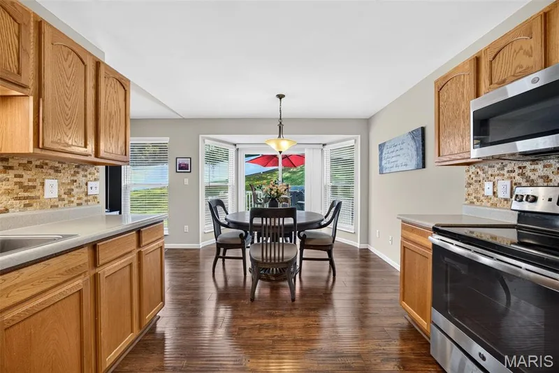 Kitchen and dining area featuring wood-finish flooring — 30 Hunting Manor Drive, St Charles, MO 63303