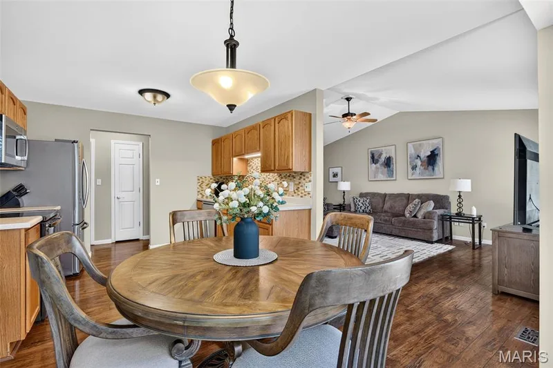 Dining area featuring a wood-finish round table and coordinating chairs under a pendant light fixture — 30 Hunting Manor Drive, St Charles, MO 63303