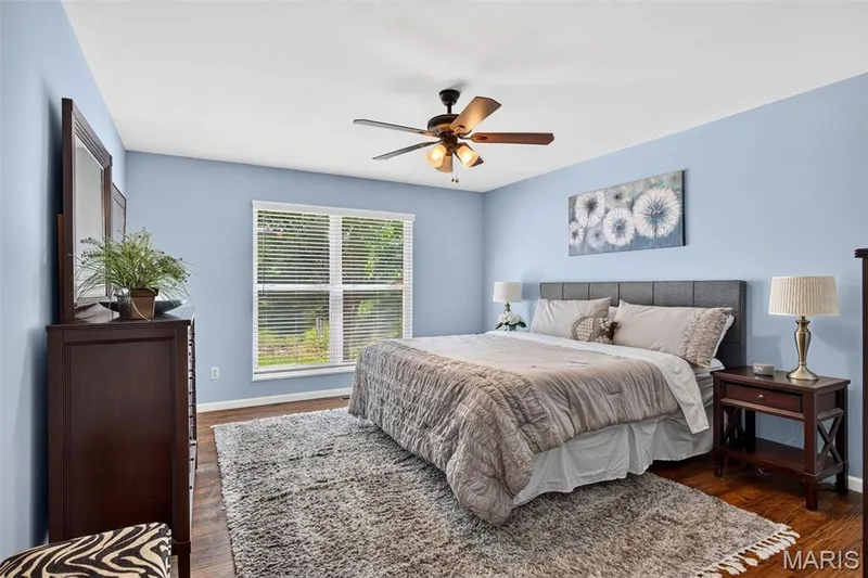 Bright room featuring wood-finish flooring and light blue walls — 30 Hunting Manor Drive, St Charles, MO 63303