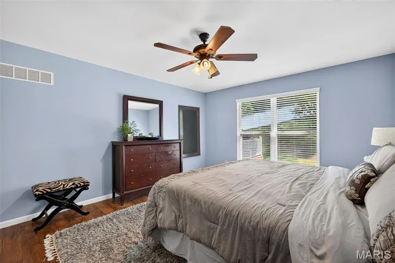 Wood-finish flooring and light blue walls create a serene atmosphere — 30 Hunting Manor Drive, St Charles, MO 63303