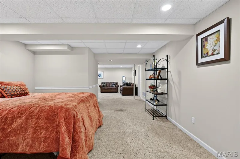 Finished lower level with neutral carpeting, recessed lighting, and a drop ceiling — 30 Hunting Manor Drive, St Charles, MO 63303