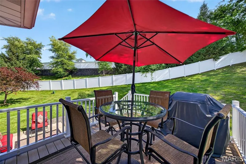 Spacious outdoor deck featuring wood-finish flooring and white railings — 30 Hunting Manor Drive, St Charles, MO 63303