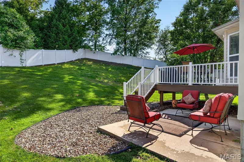 Tiered backyard featuring a concrete patio, a gravel bed, and a sloped lawn — 30 Hunting Manor Drive, St Charles, MO 63303