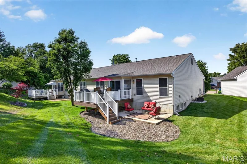 Spacious backyard featuring a multi-level deck, a lower concrete patio, and a separate screened-in porch — 30 Hunting Manor Drive, St Charles, MO 63303
