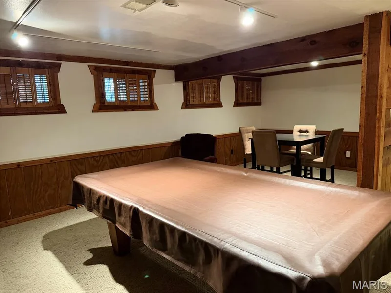 Exposed wooden beams, wood-paneled wainscoting, and wood-framed windows with louvered shutters create a distinctive aesthetic — 14238 Kinderhook Drive, Chesterfield, MO 63017